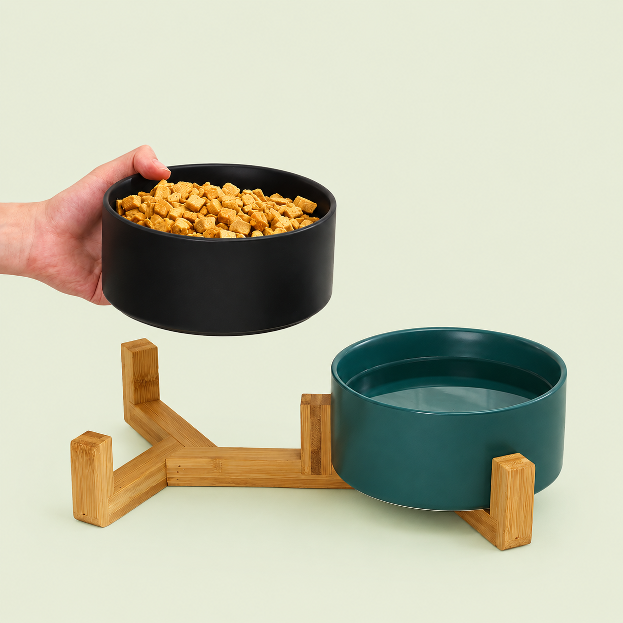 Bol en céramique noir rempli de friandises et bol vert d'eau sur support en bambou pour chat