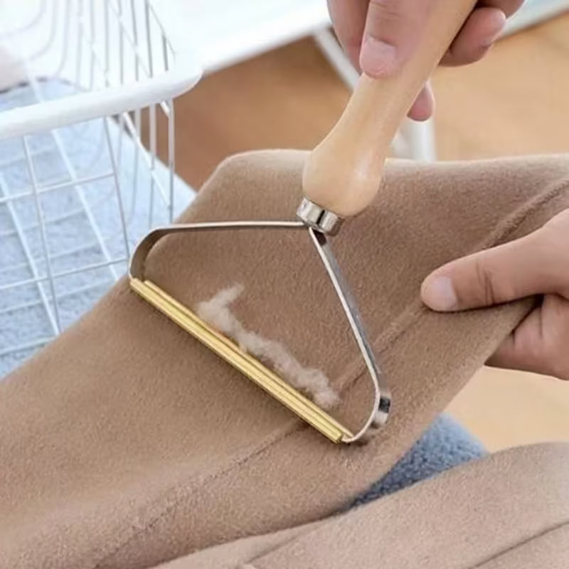 Rasoir à peluches manuel avec manche en bois utilisé sur un tissu beige pour enlever les bouloches